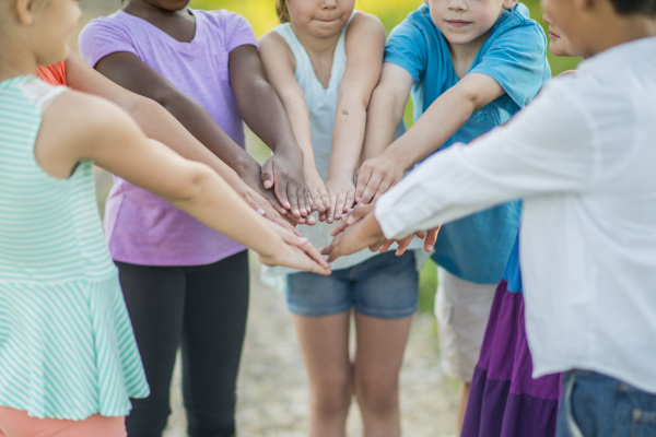 People joining hands in the middle of a circle